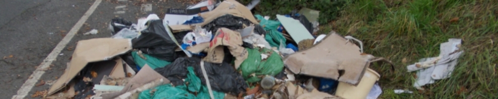 Fly tipping rubbish dumped by the side of a road